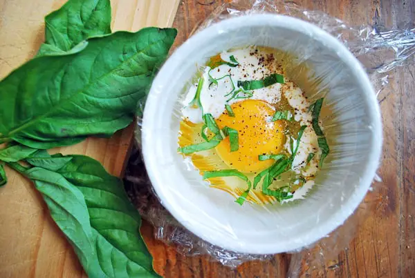 Huevo crudo en un bowl con albahaca