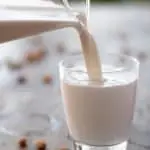 sirviendo leche de almendras en un vaso