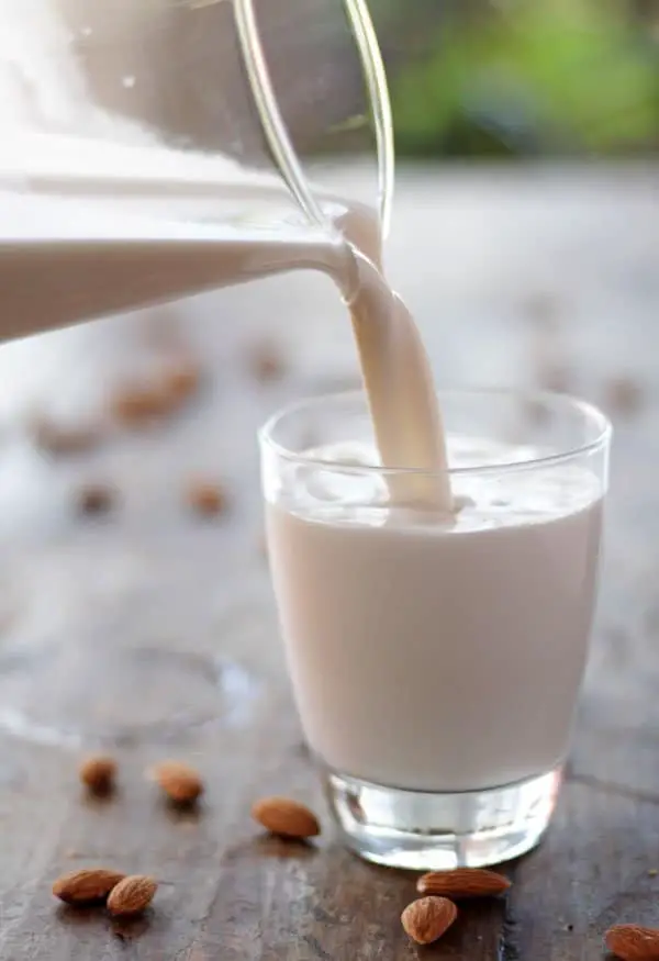 sirviendo leche de almendras en un vaso