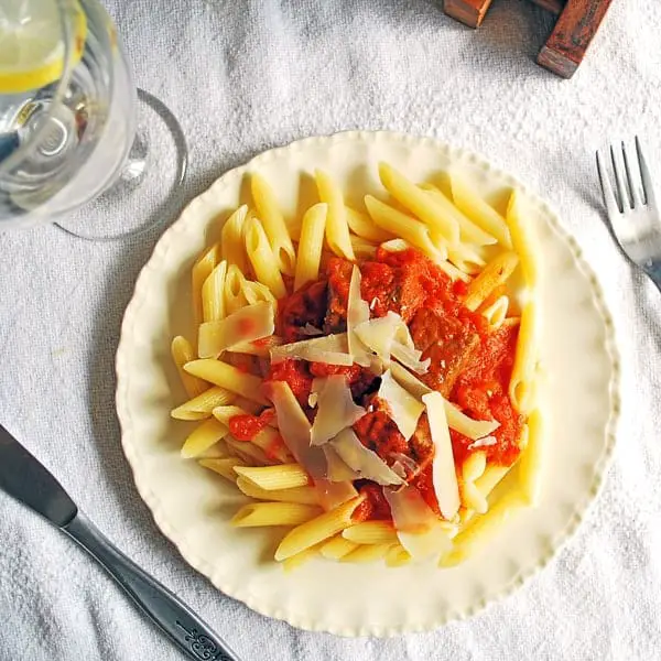 Plato de pasta con salsa ragú servido en un plato