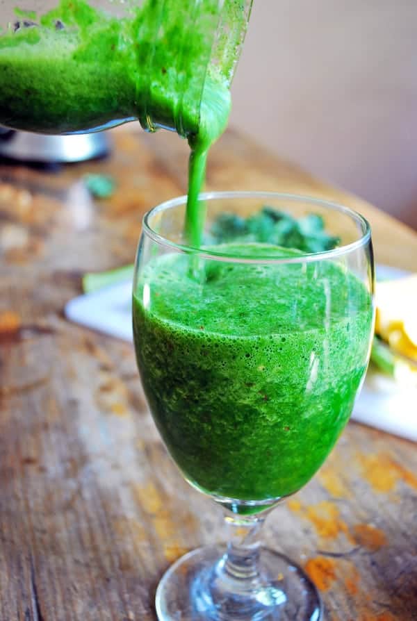 sirviendo smoothie verde en una copa