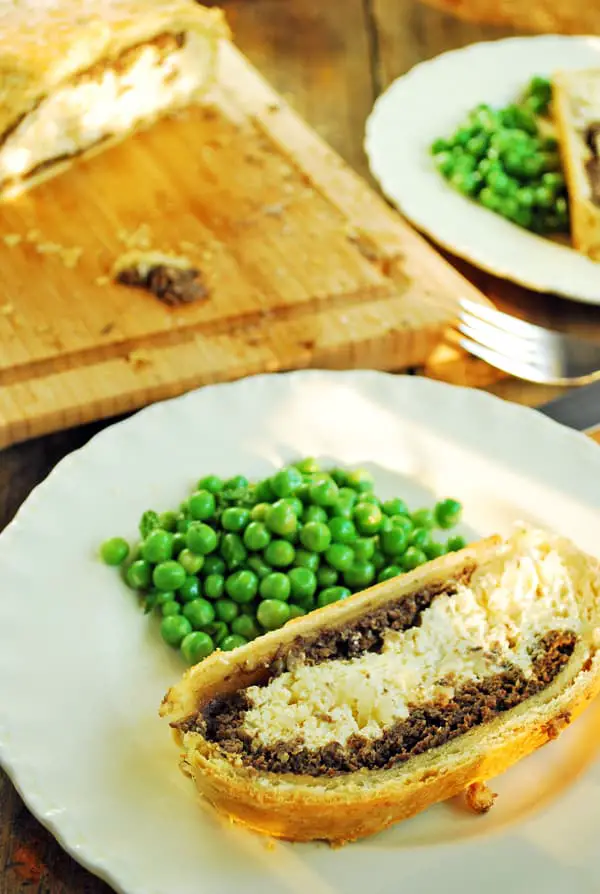 wellinton vegetariano servido con unos chícharos