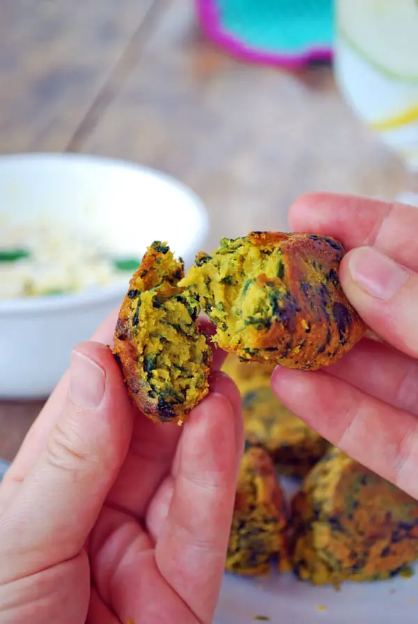 una mano rompiendo por la mitad un kofta de garbanzo