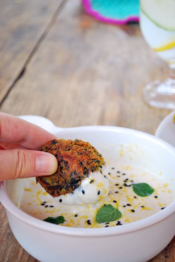 sumergiendo un kofta de garbanzo en salsa de yogurt