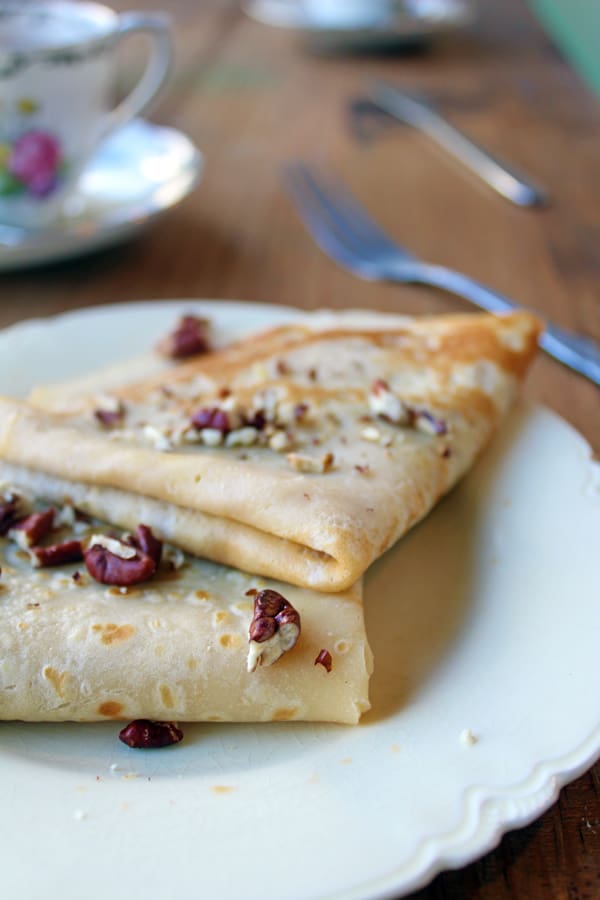 crepas servidas en un plato, con nueces troceadas por encima. 