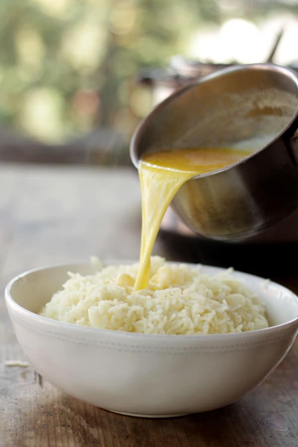 agregando leche caliente sobre papas para preparar puré de papa