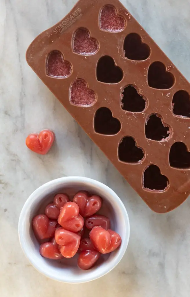 molde con gomitas de fresa y un recipiente hondo con varias gomitas